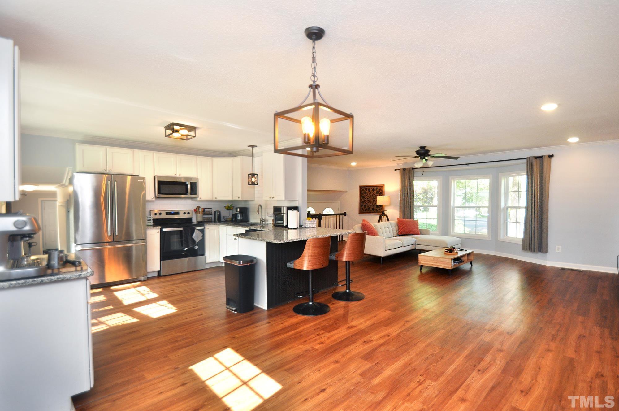 2401 Sanderford Road Raleigh, NC 27610 - Photo 4 of 31 a view of a kitchen and dining room with wooden floor windows
