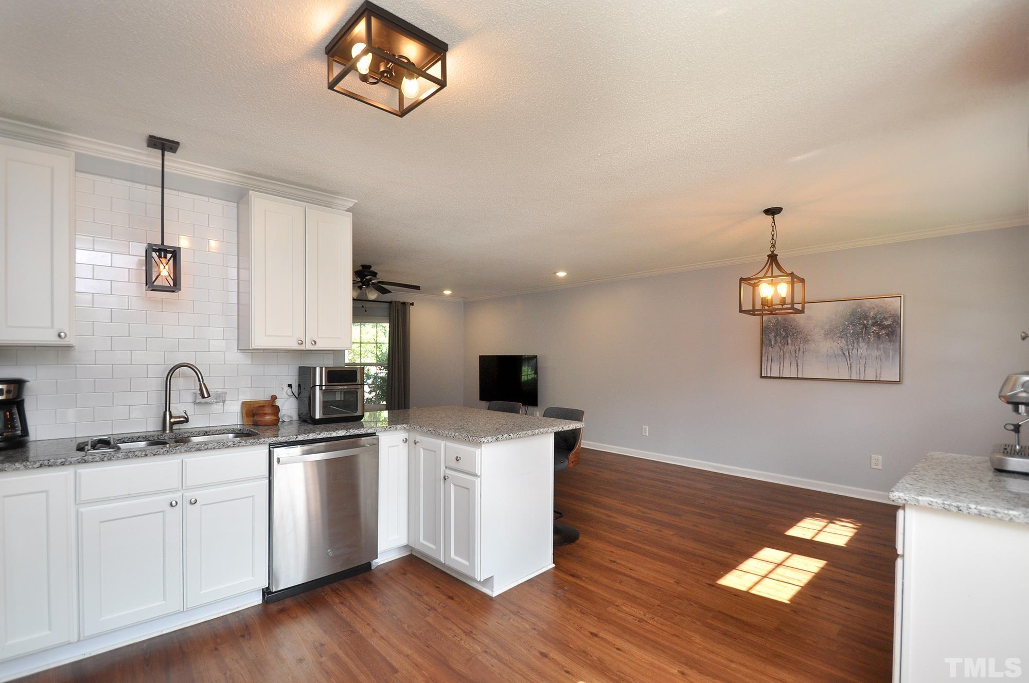 2401 Sanderford Road Raleigh, NC 27610 - Photo 9 of 31 a kitchen with a sink cabinets and wooden floor