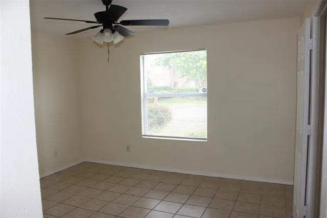 an empty room with a window and a fan