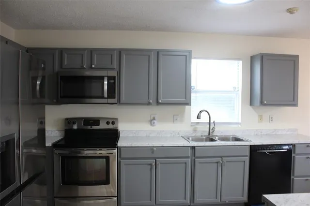 a kitchen with sink a microwave a stove and refrigerator
