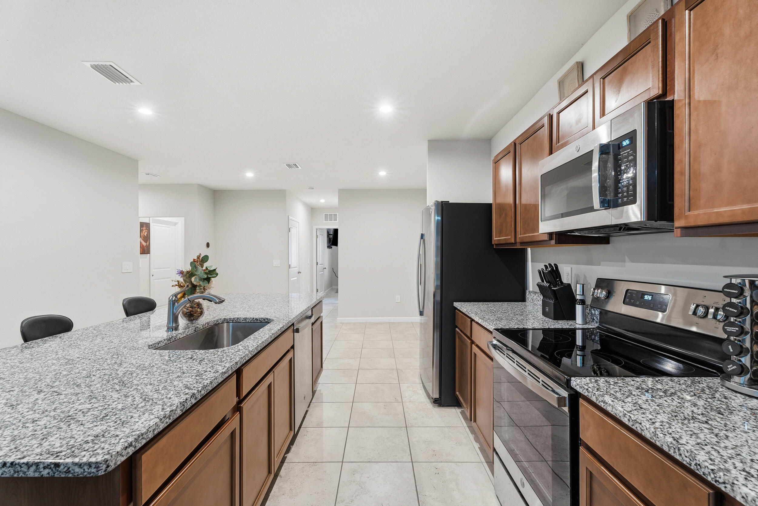 271 Raspberry Road Fort Pierce, FL 34981 - Photo 3 of 42 a kitchen with granite countertop stainless steel appliances a sink a stove top oven a counter space and cabinets