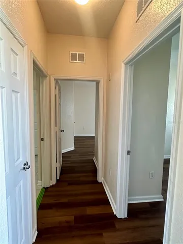 a view of a hallway with wooden floor and entryway