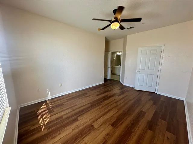 a view of room with wooden floor and white walls
