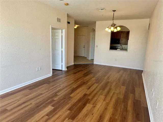 a view of a room with wooden floor and chandelier