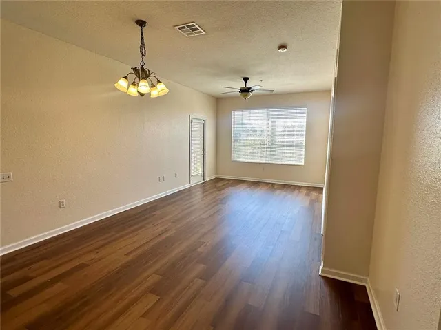 a view of a room with wooden floors and ceiling fan