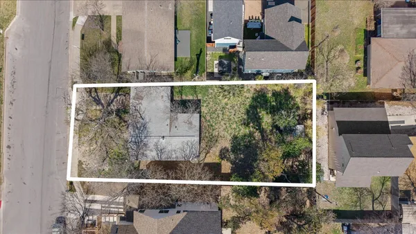 an aerial view of a house with a yard and large trees
