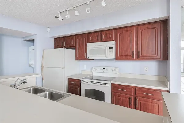 a kitchen with granite countertop a sink stove and refrigerator