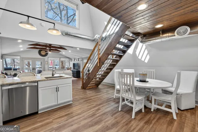 a kitchen with a dining table chairs sink and cabinets