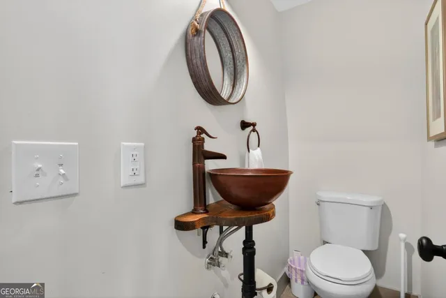 a bathroom with a toilet a sink and a mirror