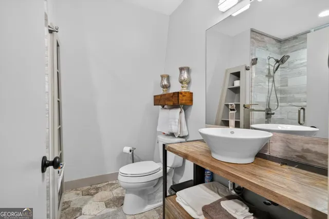 a bathroom with a granite countertop toilet a sink and a bathtub
