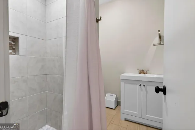 a bathroom with a sink a toilet and shower