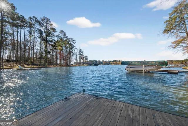 a view of a house with a large tree and wooden fence