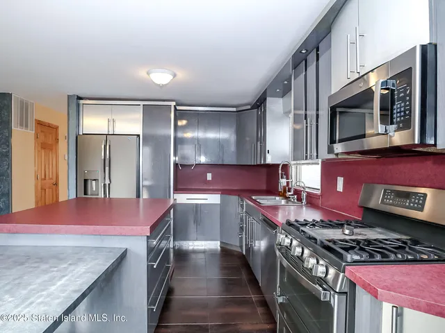 a kitchen with stainless steel appliances granite countertop a stove and a microwave