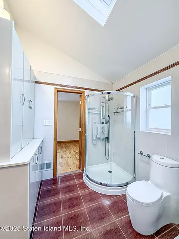 a bathroom with a glass shower door and a toilet