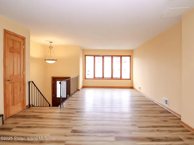 a view of an empty room and wooden floor
