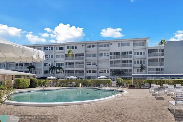 a view of a swimming pool with a lawn chairs and a barbeque