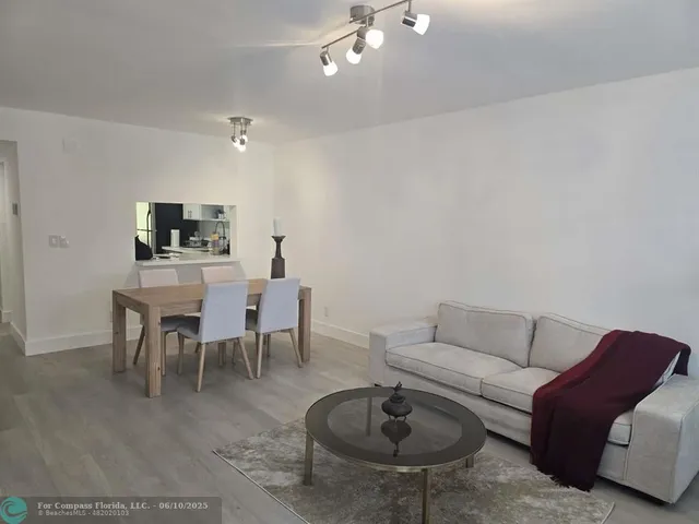 a living room with furniture and a dining table