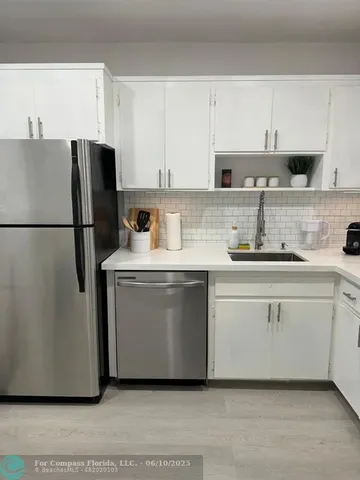 a kitchen with stainless steel appliances a refrigerator sink and cabinets