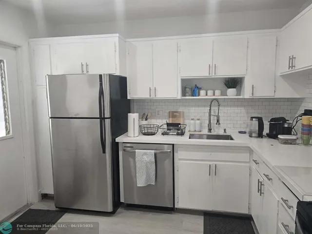 a kitchen with a refrigerator sink stove and cabinets