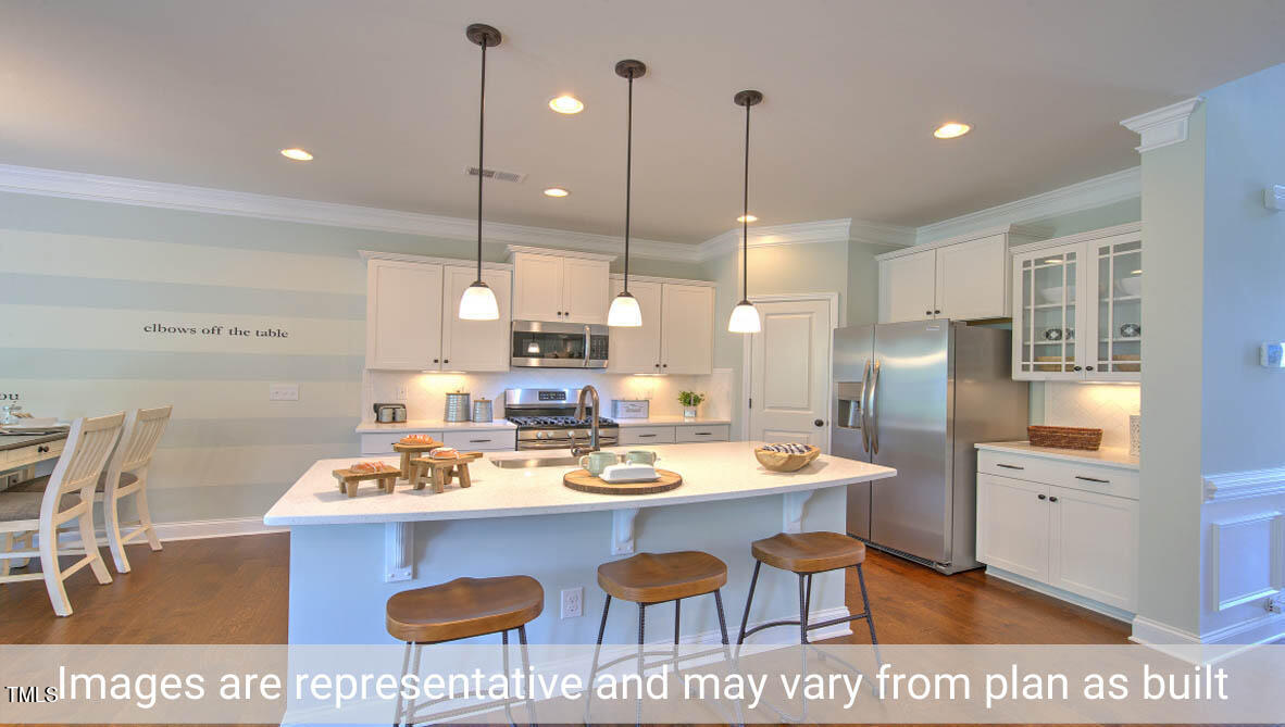 1857 Old Fields Boulevard Haw River, NC 27258 - Photo 21 of 53 a kitchen with stainless steel appliances granite countertop a sink a stove a refrigerator a dining table and chairs with wooden floor