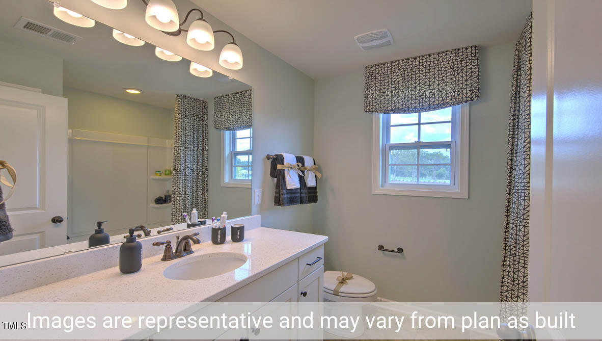 1857 Old Fields Boulevard Haw River, NC 27258 - Photo 26 of 53 a bathroom with a sink a mirror and a vanity