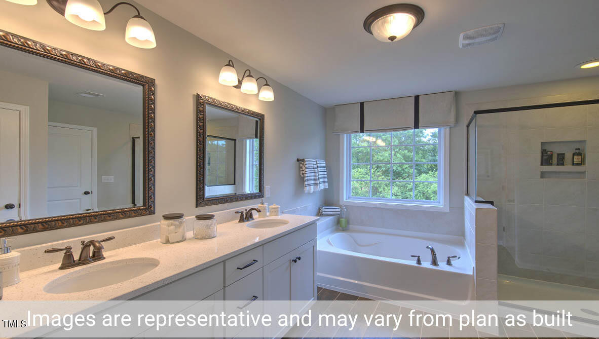 1857 Old Fields Boulevard Haw River, NC 27258 - Photo 48 of 53 a bathroom with a tub a sink and a large mirror