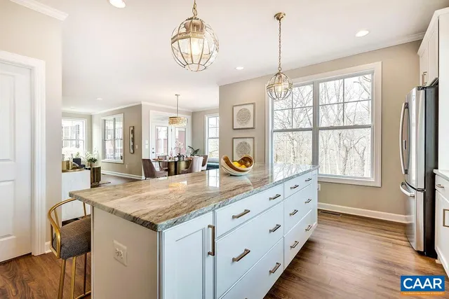 a kitchen with granite countertop white cabinets and chandelier