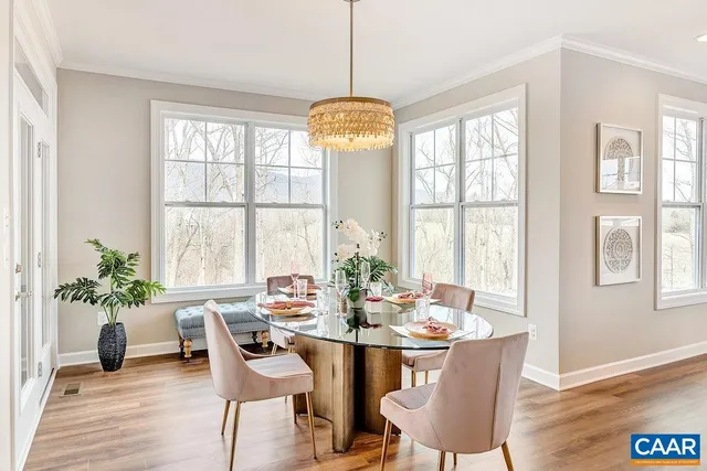 a dining room with furniture potted plants and wooden floor