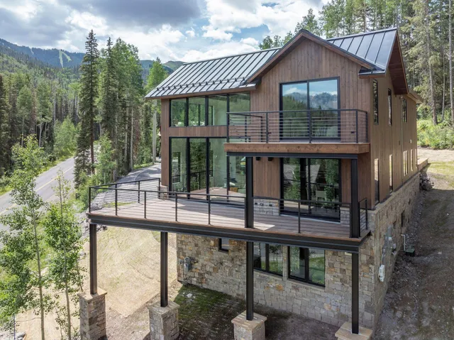 a view of house with a yard and balcony