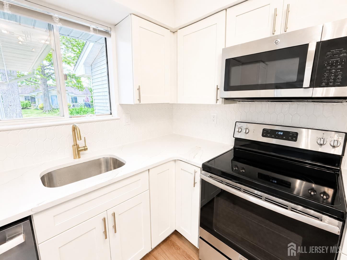 621 A Deal Road Monroe Township, NJ 08831 - Photo 9 of 27 a kitchen with stainless steel appliances a stove a sink and a microwave