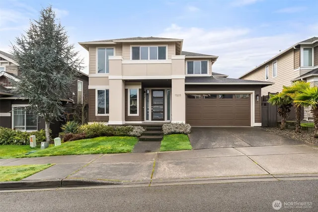 a front view of a house with a yard and a garage
