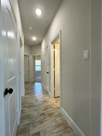 a view of a hallway with wooden floor