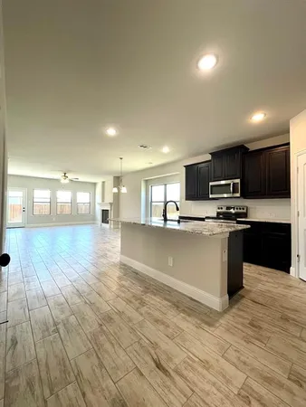 a kitchen with stainless steel appliances granite countertop a stove a sink and a refrigerator