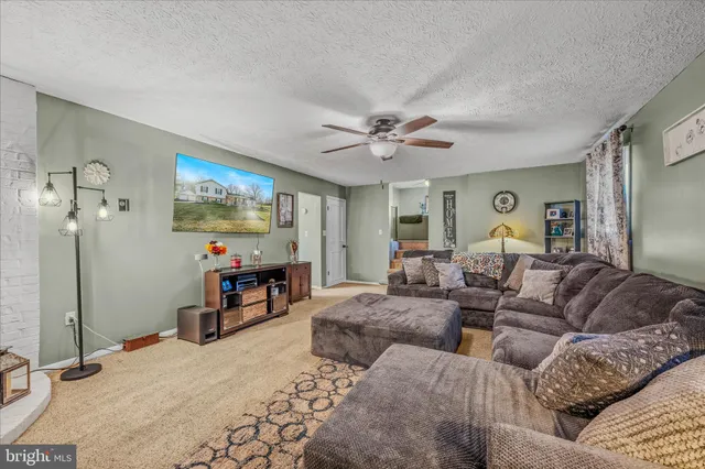 a living room with furniture a large window and dresser