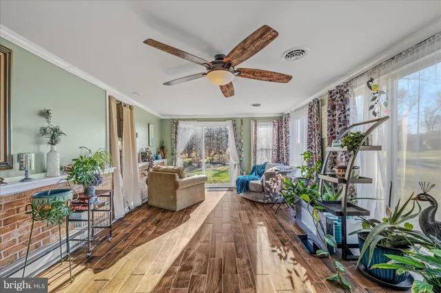 a dining room with furniture potted plants and wooden floor