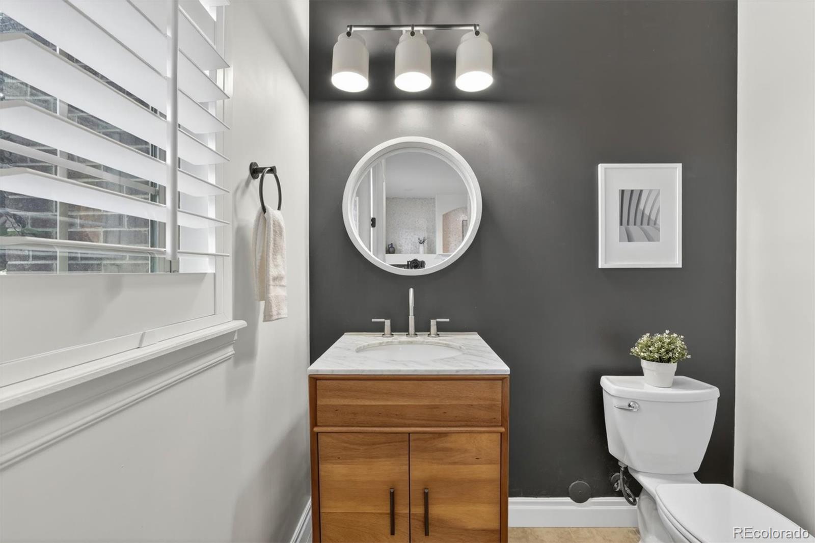 10126 RidgeGate Circle Lone Tree, CO 80124 - Photo 8 of 32 a bathroom with a toilet a sink and a mirror