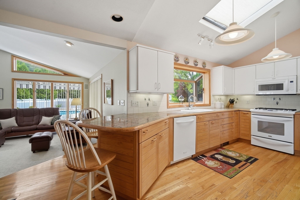30 Birch Hill Road Northampton, MA 01062 - Photo 9 of 42 a kitchen with granite countertop a stove a sink a dining table and chairs with wooden floor