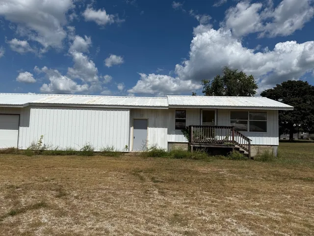 a backyard of a house with table and chairs