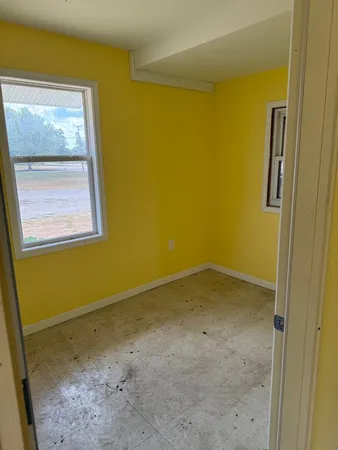 a view of a small space with wooden floor and a window