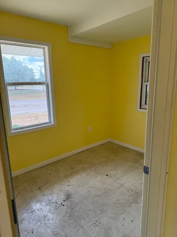a view of a small space with wooden floor and a window