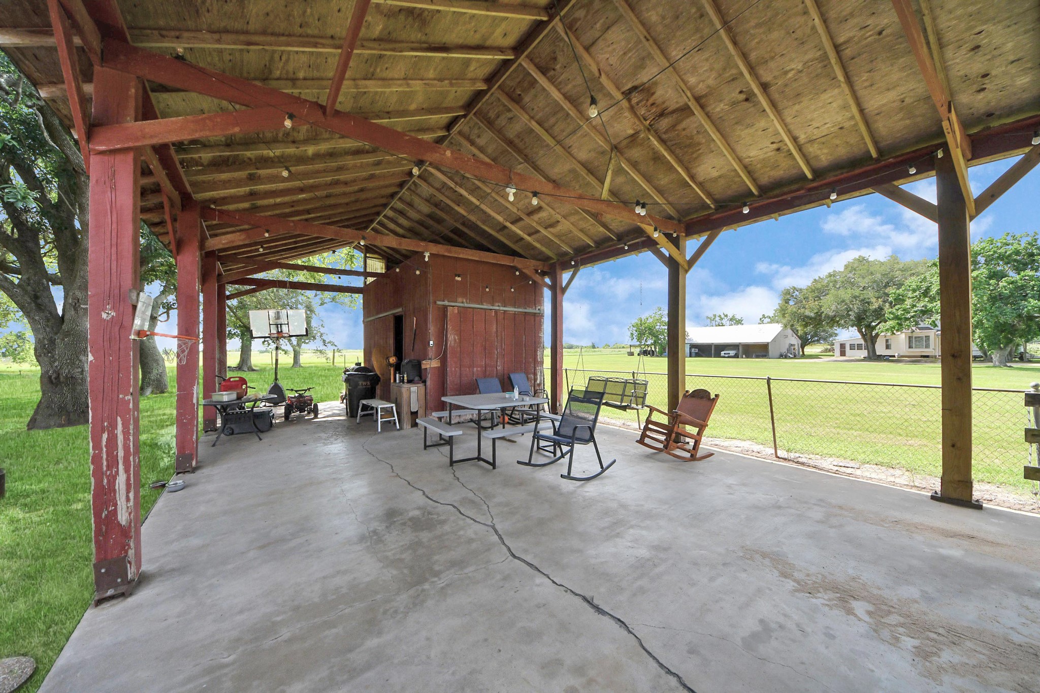 2990 FM 1163 Road El Campo, TX 77437 - Photo 19 of 50 a view of a patio with table and chairs under an umbrella with a large tree