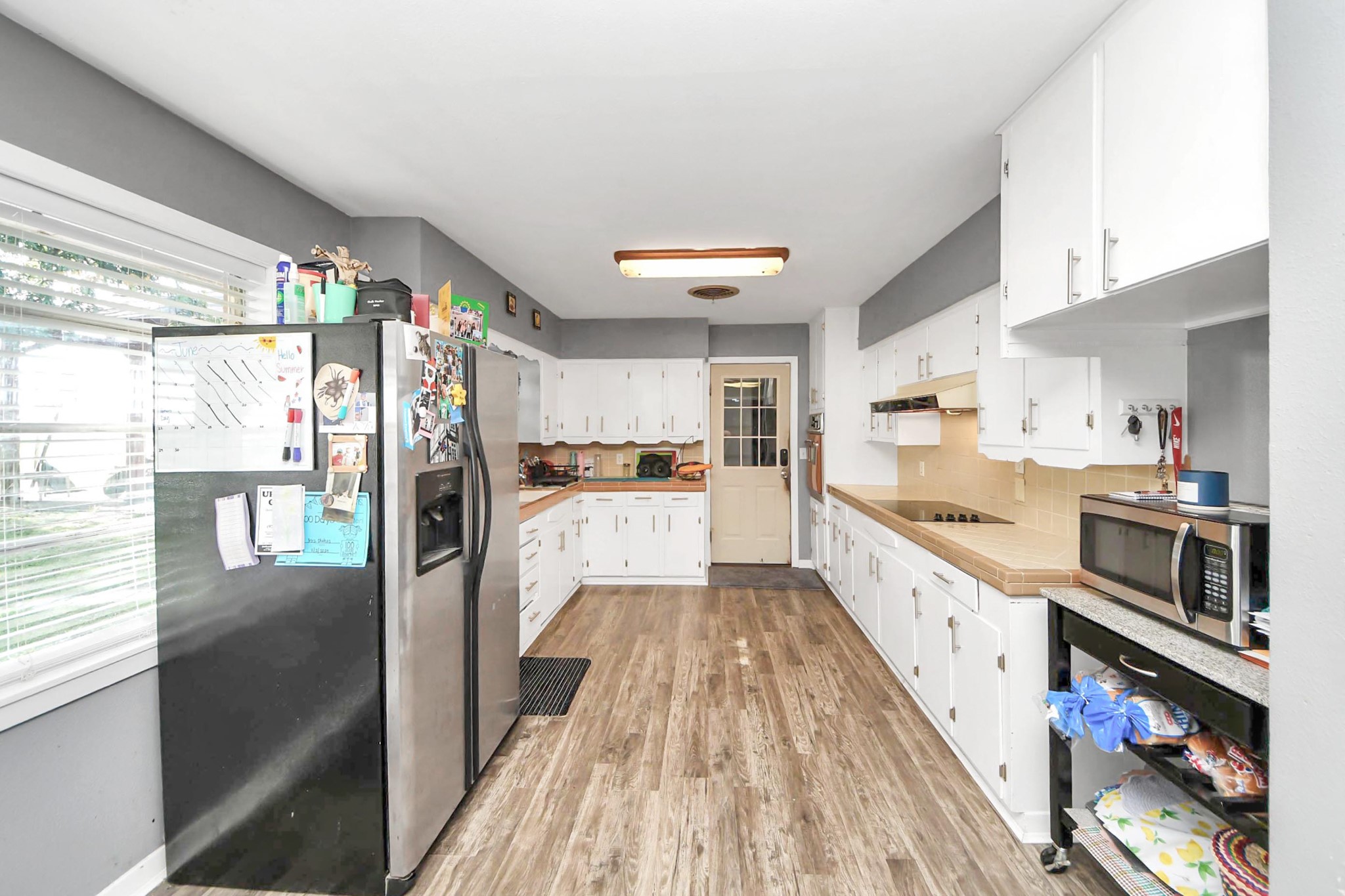 2990 FM 1163 Road El Campo, TX 77437 - Photo 24 of 50 a kitchen with stainless steel appliances kitchen island granite countertop a refrigerator a sink dishwasher a stove and a dining table with wooden floor