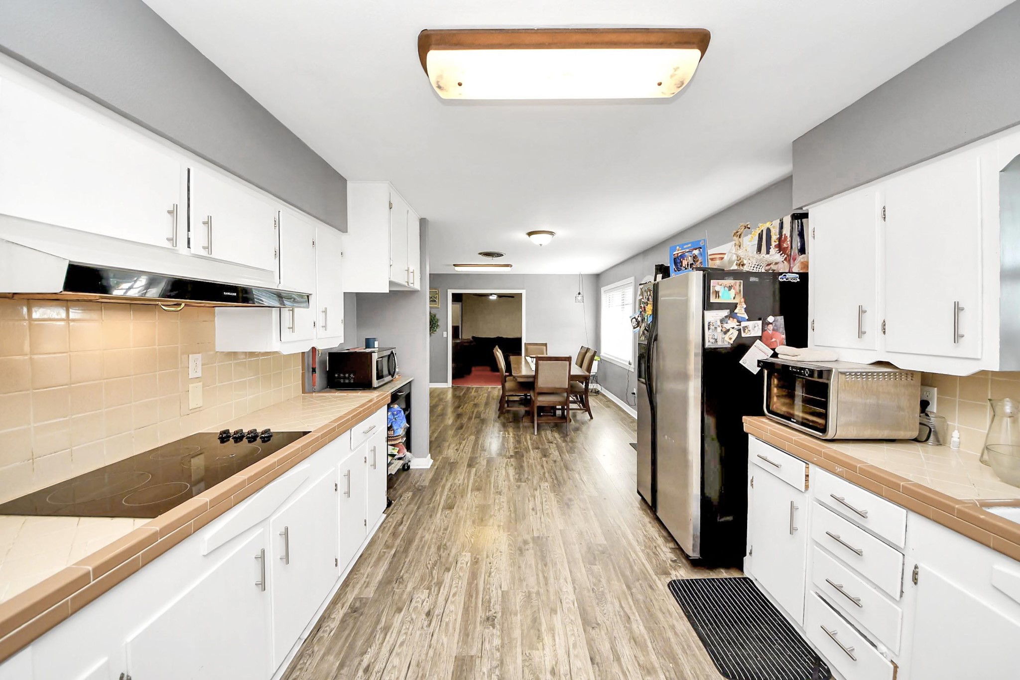 2990 FM 1163 Road El Campo, TX 77437 - Photo 29 of 50 a kitchen with stainless steel appliances granite countertop a refrigerator oven a sink dishwasher and white cabinets with wooden floor