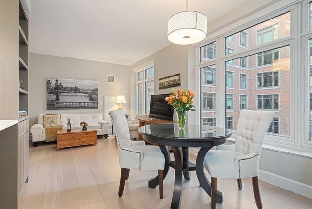 a kitchen with stainless steel appliances a large center island attached withe living room