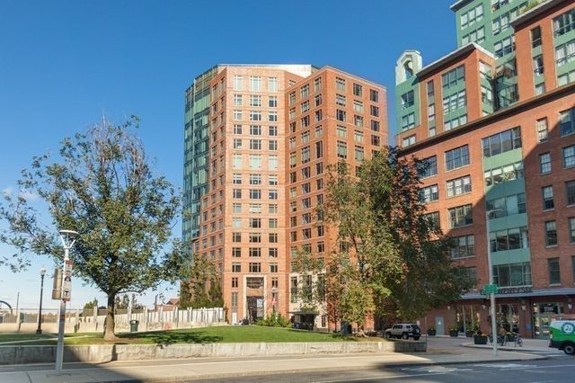 a view of a building with a street sign on a sidewalk
