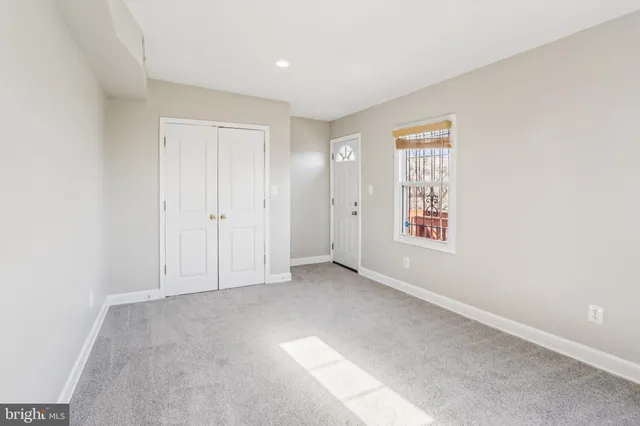 an empty room with windows and closet