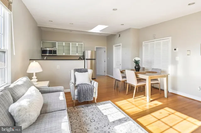 a living room with furniture a dining table and a rug