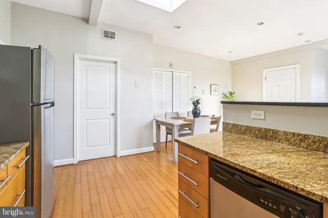 a kitchen with granite countertop a sink cabinets and stainless steel appliances