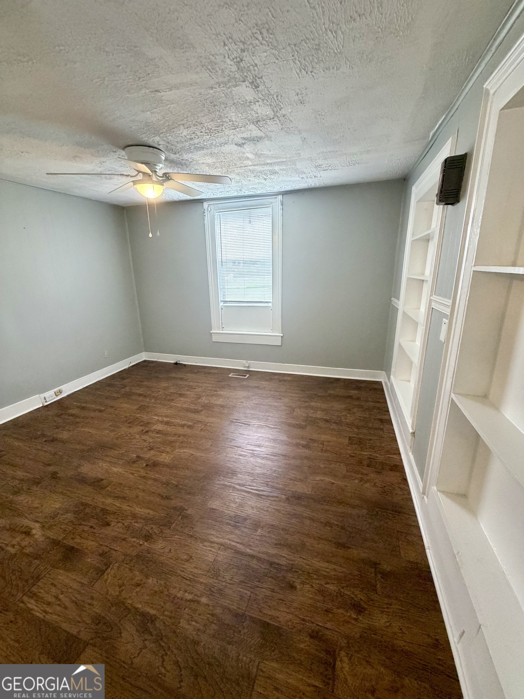 666 Woolfolk Street Macon, GA 31217 - Photo 17 of 60 an empty room with wooden floor and windows