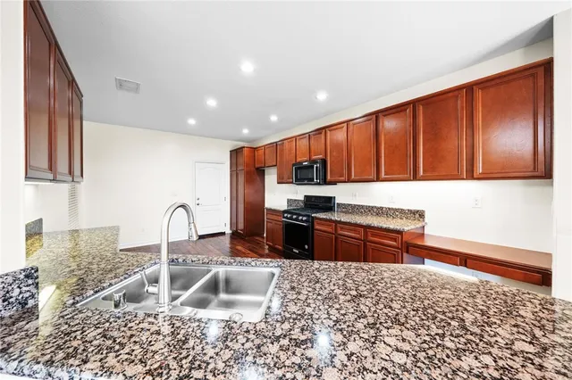 a kitchen with stainless steel appliances granite countertop a stove and a sink